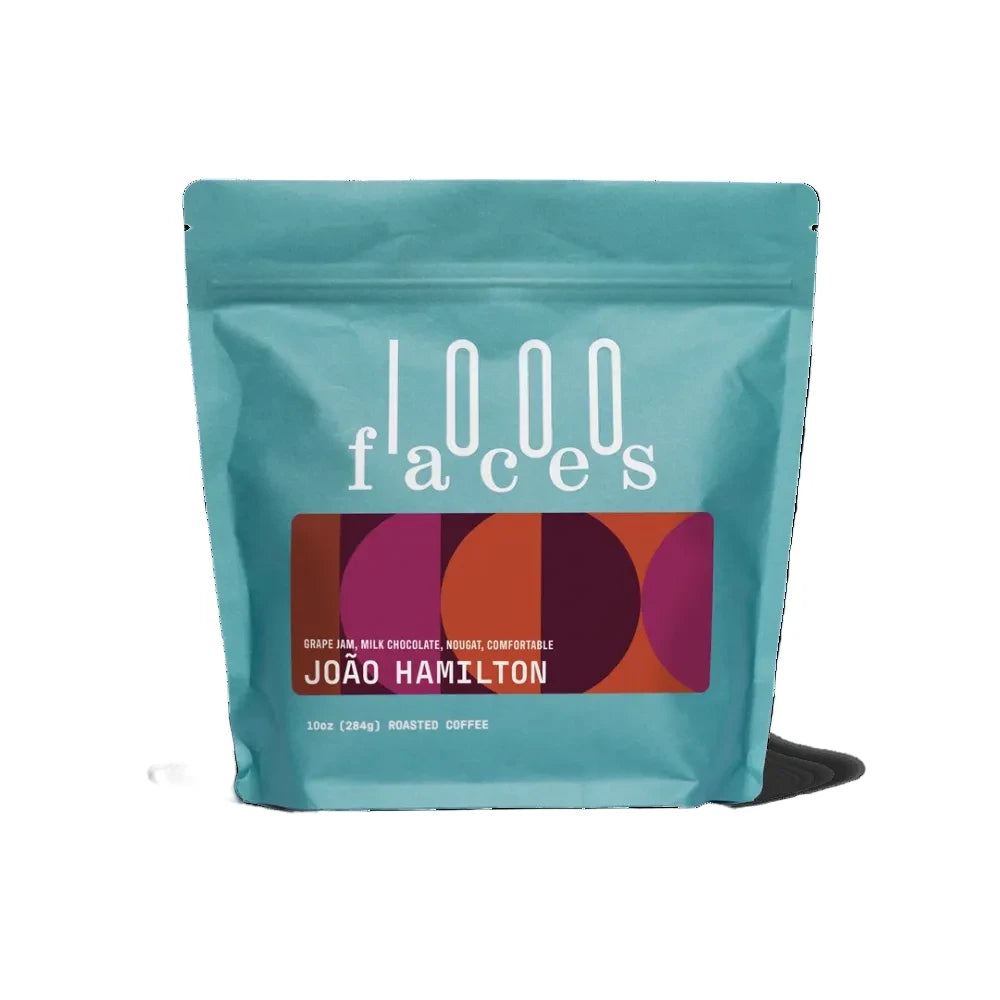 A teal stand-up pouch of 1000 Faces João Hamilton roasted coffee on a clean white background. – 1000Faces Coffee main product