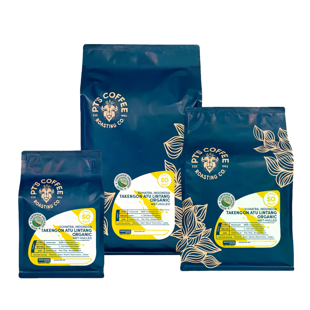 Three bags of Pts Coffee Roasting Co. organic coffee beans in dark blue packaging with gold and white labels, arranged on a white background. – PT's Coffee main product