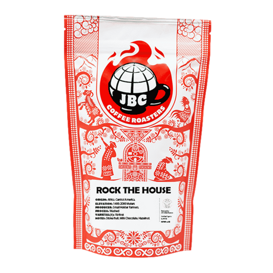 A bag of JBC Coffee Roasters 'Rock the House' blend coffee, with a red and white design featuring decorative patterns and the JBC logo.