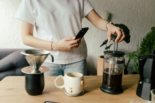 Woman making coffee with a French press and pour-over