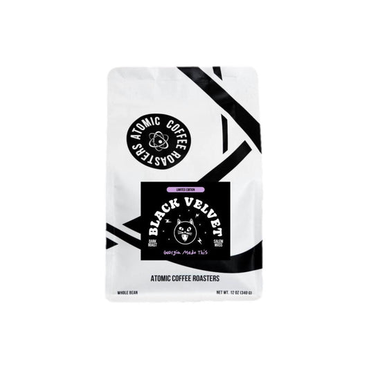 A single stand-up coffee bag from Atomic Coffee Roasters on a plain white background. The package is mostly white with bold black graphic stripes and a large black central label reading 'Black Velvet' with a cat illustration.