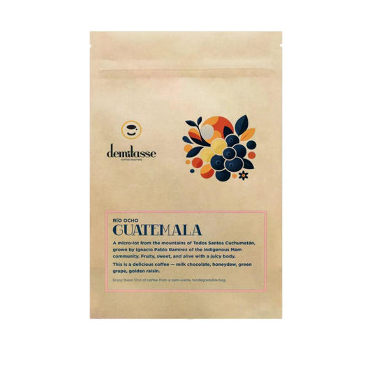 A stand-up kraft paper bag of Demlasse Bio Ocho Guatemala coffee, featuring a colorful graphic of coffee cherries and descriptive text on a white background.