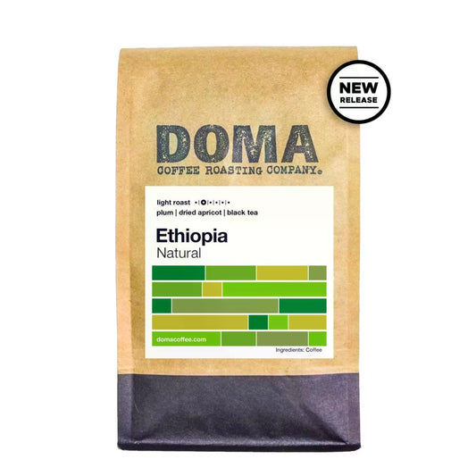 A bag of Doma Coffee Roasting Company Ethiopia Natural light roast coffee on a white background, featuring a kraft paper bag with a white label and a black circular 'NEW RELEASE' badge.