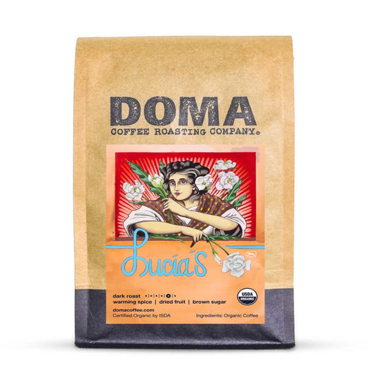 A bag of Doma Coffee Roasting Company Bricia's dark roast organic coffee in a kraft paper bag with a vintage-style illustration on the front.