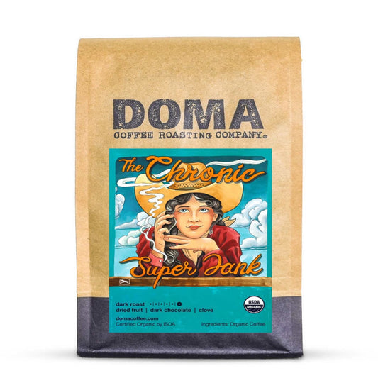 A bag of Doma Coffee Roasting Company 'The Chronic Super Jank' coffee on a white background. The packaging is a brown kraft paper bag with a teal and orange label featuring an illustration of a woman in a sombrero.