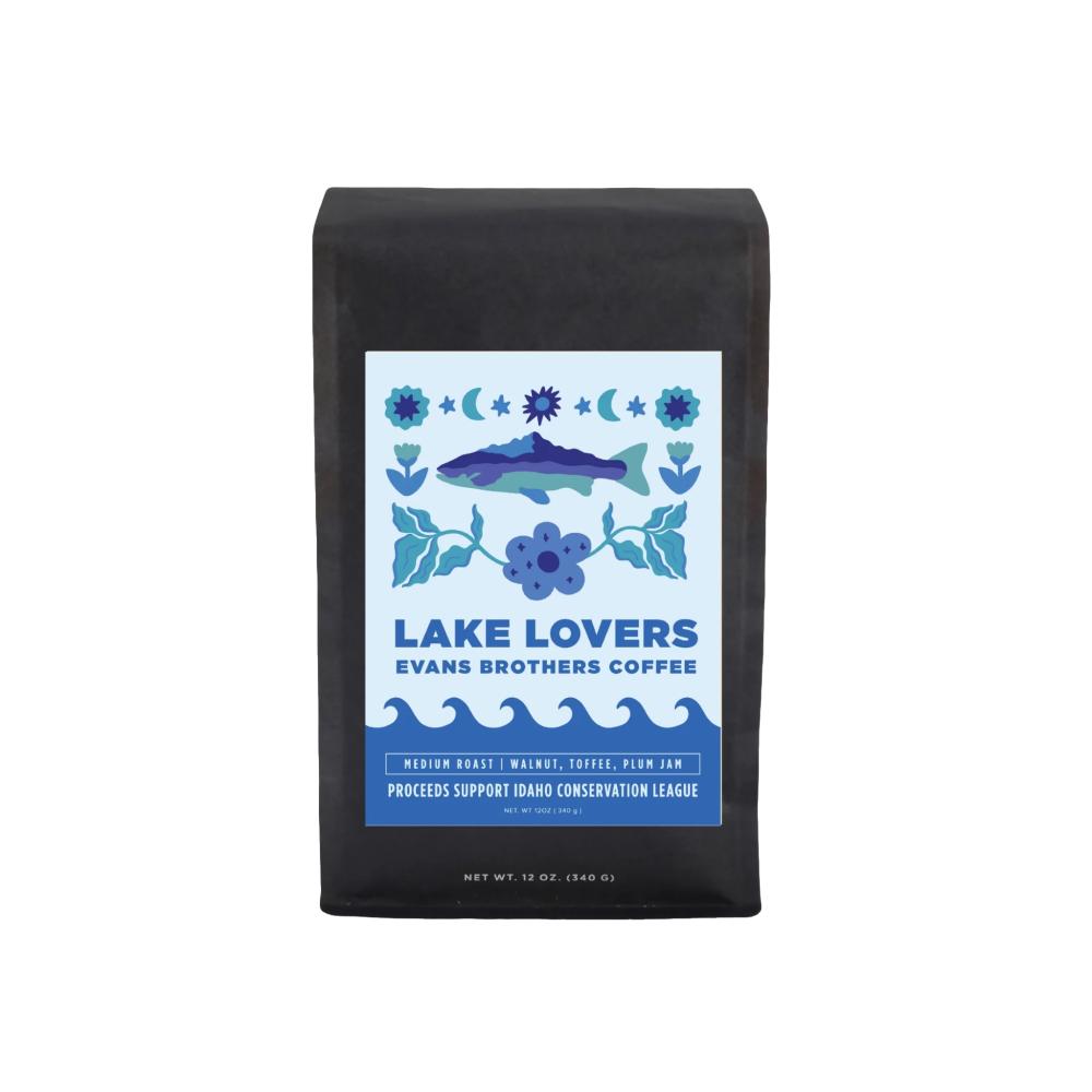 A 12 oz bag of Lake Lovers coffee by Evans Brothers Coffee, featuring a black bag with a white and blue label showing a fish and wave design.