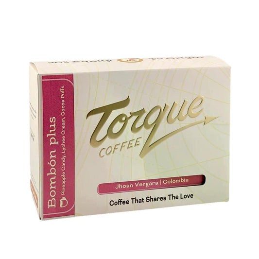 Torque Coffee packaging with gold and pink text on a white background