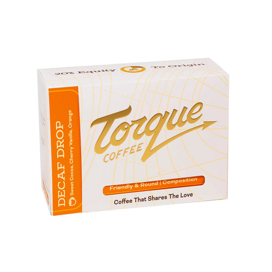 A box of Torque Coffee Decaf Drop, featuring a white and orange design with gold lettering, shown on a plain white background.