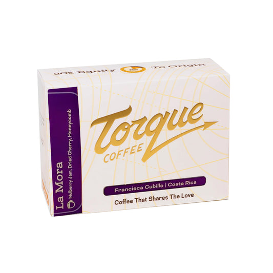 A box of La Mora Torque Coffee on a plain white background. The packaging is primarily white with gold line art and script, featuring a prominent purple side panel with the brand name 'La Mora' and a purple label on the front that reads 'Francisco Cubillo | Costa Rica'.